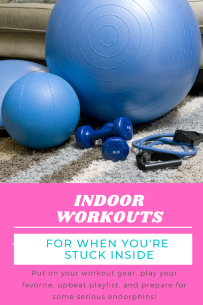 Blue exercise equipment, including a yoga ball, medicine ball, dumbbells, and resistance band, are sitting on a striped carpet.